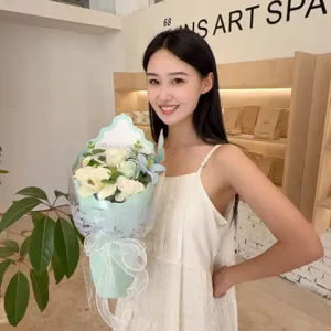 Detailed view of handmade soap flower bouquet featuring lilies and roses held by a model