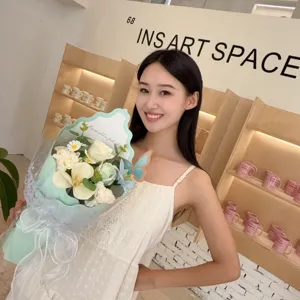 Elegant soap flower bouquet with lilies and roses held by a model for Mother's Day.