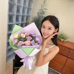 Femme asiatique souriante tenant un bouquet de fleurs de savon fait main avec roses et œillets