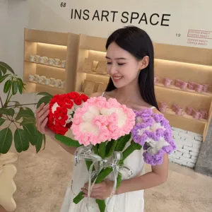 Close-up of model holding handmade knitted carnation yarn flower bouquet in café