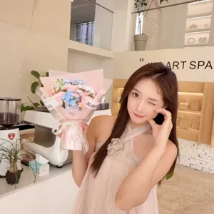 Asian woman holding a beautiful soap flower bouquet featuring pink and blue roses