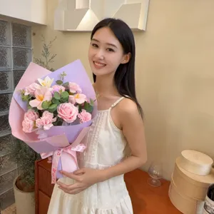 Une jeune femme élégante tenant un bouquet de roses roses et d'œillets dans un décor intérieur
