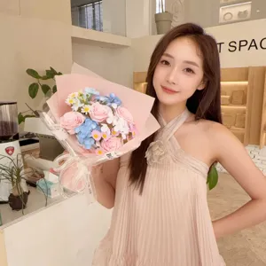 Detail view of a handcrafted pink soap rose bouquet held by a model in a cafe