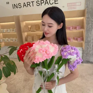 Hand-knit yarn carnation bouquet held by a woman in a minimalist art cafe setting