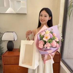Femme tenant un bouquet de roses de savon roses et d'œillets dans un sac.