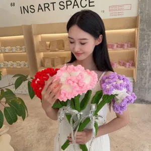 A model holding a vibrant bouquet of handmade crocheted yarn carnation flowers