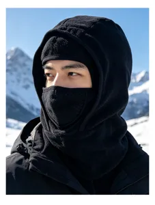 Asian male model wearing a premium black thermal balaclava for skiing in snowy mountains