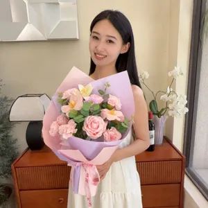 Gros plan d'une femme tenant un bouquet de fleurs de savon avec des roses et œillets.