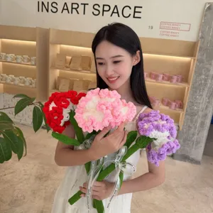 Handmade crochet carnation bouquet held by a model in a cozy cafe setting