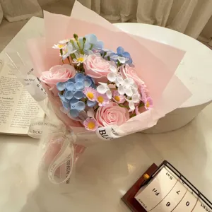Close-up of pink and blue soap flower bouquet with elegant 'Best Wishes' ribbon for gifting