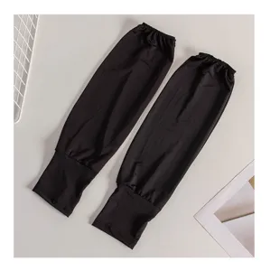 Gros plan sur les manchons de protection solaire noirs et amples en soie, poignets élastiques.