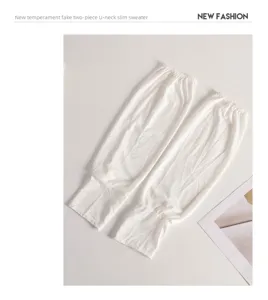 Gros plan détaillé des manches de protection solaire en soie glacée blanche et légère.