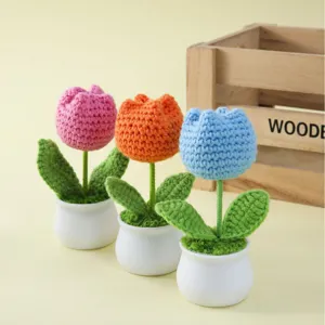 Flores de tulipanes hechas a mano a ganchillo en pequeñas macetas blancas para decorar