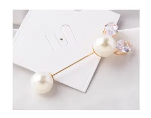 Close-up of elegant pearl safety pin brooch with sparkling crystal rabbit ear detail