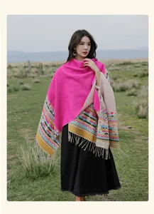 Close-up of ethnic knit shawl showing vibrant pink fabric and geometric tassel borders