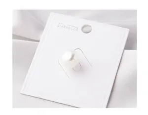 Detail of a white pearl anti-exposure pin on a white display card