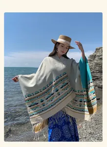 Detailed view of retro ethnic geometric shawl with tassels worn by model on beach