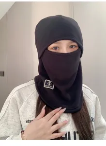 Detail view of a black winter thermal balaclava mask and neck gaiter set on a model.