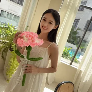 Asian model holding a large handmade pink crochet carnation flower for Teacher's Day gift