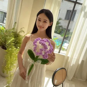 Handmade crochet purple carnation held by model in a soft indoor setting