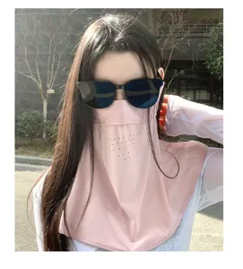 Detail view of woman wearing pink UV protection sun mask and neck gaiter outdoors