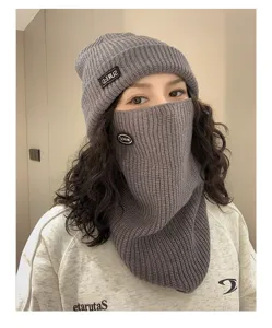 Primer plano de un conjunto de gorro de punto y calentador de cuello gris para el invierno