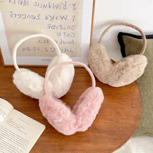 Set of three plush faux fur earmuffs in white, pink and camel for winter warmth.