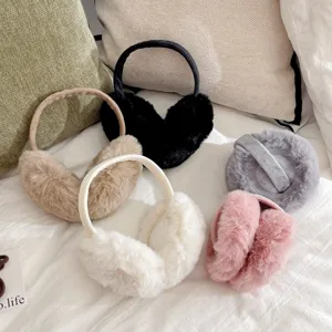 A collection of soft plush winter earmuffs in various colors on cozy white bedding