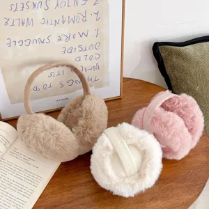 Soft plush winter earmuffs for women in multiple colors displayed on a cozy wooden table