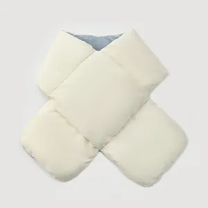 Detail view of a thickened quilted winter neck warmer in cream white with blue lining.