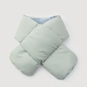 Detail of a minimalist light green padded quilted scarf with soft blue lining