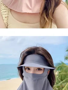 Dettaglio di una donna con maschera protettiva UV grigia in seta ghiaccio al mare