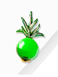 Macro view of a vibrant green jelly glass pineapple brooch with sparkly rhinestone leaves