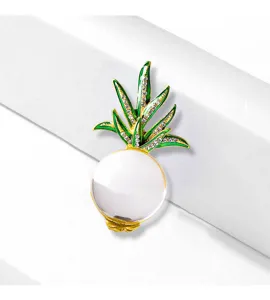 Macro detail of a stunning 3D pineapple brooch with crystal leaves and glass bead.