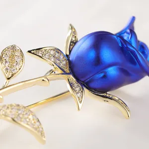 Detailansicht einer eleganten blauen Rosenbrosche mit glitzernden Strassblättern