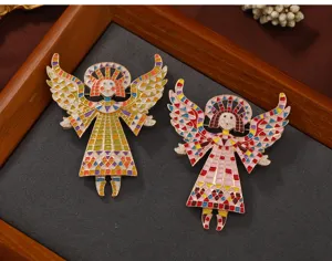 Detailed view of two vintage enamel angel brooches with colorful mosaic wings