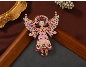 Detailed view of a vintage colorful painted angel brooch with geometric wings on wooden prop