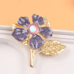 Detailed view of a purple cherry blossom brooch with cat-eye stone and golden leaves