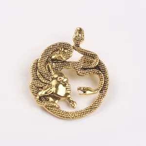 Dettaglio macro di una spilla Medusa in oro vintage con trame di serpente molto intricate