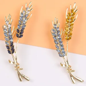 Detailopname van elegante tarwe-aar broches met sprankelende blauwe en gele strass.