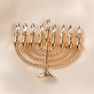 Detailed view of a golden Hanukkah Menorah brooch with sparkling clear crystal rhinestones