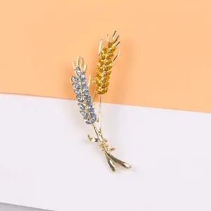 Elegante tarwe-broche met gele en blauwe kristallen in een luxe gouden afwerking