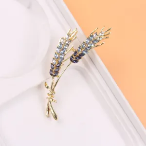 Detail van een elegante tarwe-aar broche met fonkelende blauwe strass steentjes.