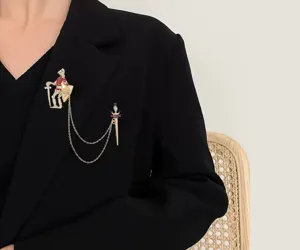 Detailopname van een vintage gouden kettingbroche met soldaat- en zwaardhangers op een zwarte blazer