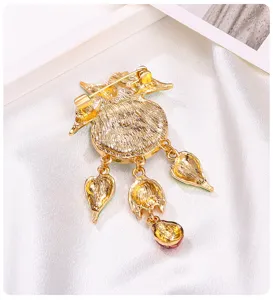 Vue détaillée de l'arrière d'une broche dorée de style vintage avec pendentifs à glands.