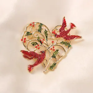 Detailed view of an alloy heart-shaped wreath brooch featuring two red cardinal birds