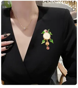 Vue détaillée d'une broche en émail vintage avec lune souriante et pompon coccinelle.