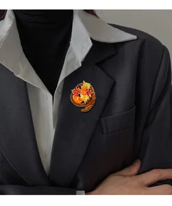 Detailed macro view of the vintage enamel maple leaf brooch pinned on a dark office blazer.