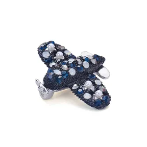 Detailansicht einer eleganten Flugzeug-Brosche mit blauen Kristallen und weißen Perlen.