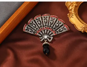 Prachtig detail van vintage waaierbroche met rode strasstenen en kristallen hanger